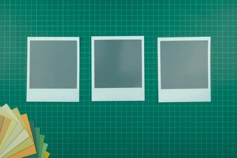 Top down view of blank instant film style photographs on cutting mat with col Stock Photos