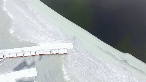 Top-down view of boathouses at partly frozen lake Stock Footage 86178878