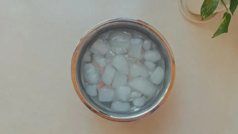 Top down view bowl of ice for face ice bath morning routine skincare wellness Stock Footage 332820735