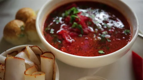Top down view of a bowl of traditional beetroot soup, garnished with chopped Stock Footage 335217804