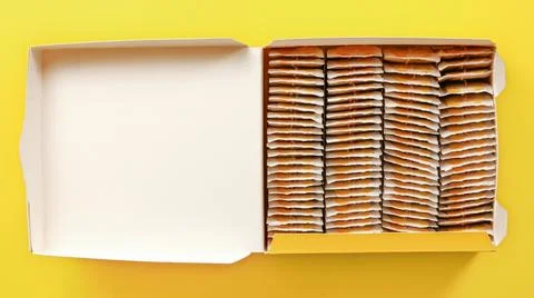 Top down view, box full of tea bags on yellow board. Stock Photos