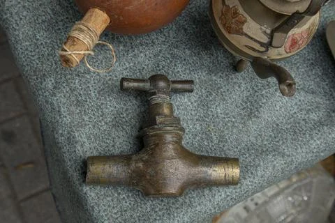 Top down view of brass water valve key on textured fabric surface in a vint.. Stock Photos