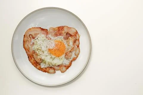 A top-down view of a breakfast dish featuring a fried egg with a runny yolk.. Stock-Fotos