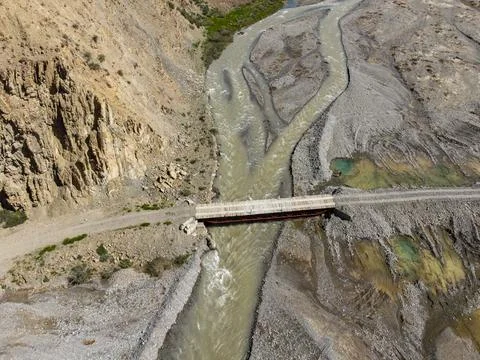 Top-down view of a bridge over a rocky river Stock Photos