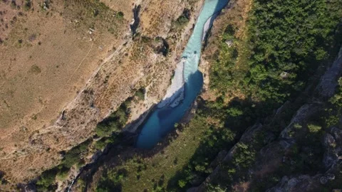 Top down view of bright turquoise river in deep rocky canyon  Видео 334324156