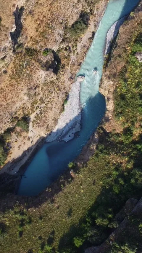  Top down view of bright turquoise river in deep rocky canyon with shadows Stock Footage 336690532