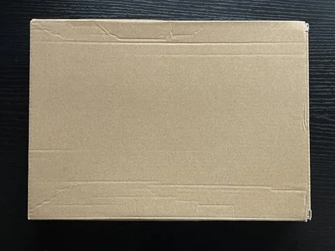 Top-Down View of Brown Cardboard Box on Dark Wood Surface Stock-Fotos