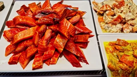 A top-down view of a buffet display shows trays of roasted eggplant and carrots Stock Footage 331959737