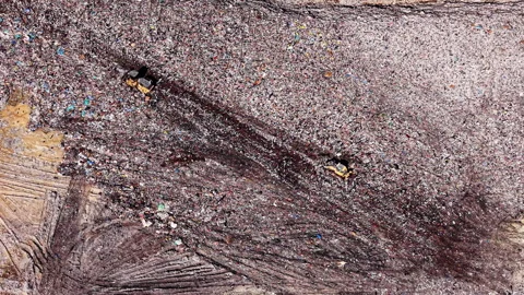 Top down view of bulldozers shifting rubbish at landfill 스톡 동영상 335690131