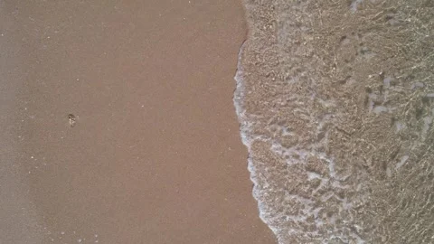 Top down view of a calm sea wave washing over a sandy beach. The Concept of.. 库存影片 332600200
