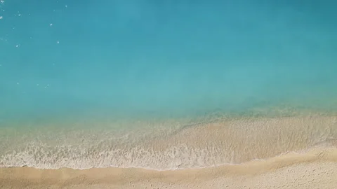 Top down view of calm turquoise sea touching sandy shoreline Stock Footage 320534824