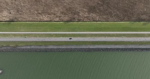 Top down view on car driving along the water. Transportation and mobility Stock Footage 302753629