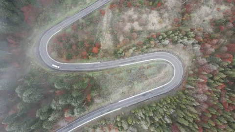 Top-down view of a car going through a serpentine road, driving along a winding Stock Footage 147270651