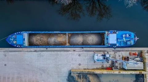 Top-Down View of Cargo Ship Loading at Dock The image presents a top-down ... Stock Photos
