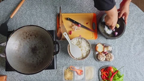 Top-down view of chef adding salt and grinding garlic and shallots with stone Stock Footage 342083821