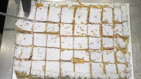 Top-Down View of Chef Cutting Cake Into Small Slices for Party Stock Footage 336793748