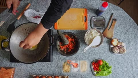 Top-down view of chef frying egg in hot wok filled with oil, flipping it over Stock Footage 342679348