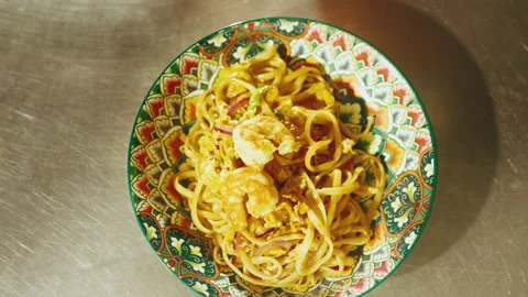 Top Down View of Chef Placing Shrimp on Pad Thai Noodles Stock Footage 321861060