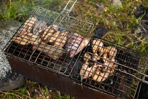 Top down view chicken wings in metal grate grilling on brazier Fotos de archivo