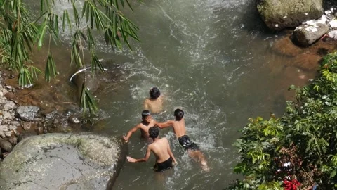 Top down view of children sitting on river rocks. Stock Footage 336322165