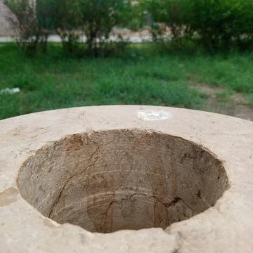 Top down view of circular carved hole in smooth beige stone block outdoors Stock Photos