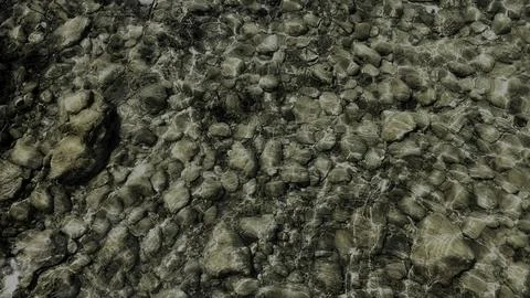 Top-Down View of Clear Water Rippling Over Pebbles and Rocks 스톡 사진