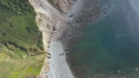 Top Down view of Cliffs and Farms over North Devon and Cornwall Coastpath Border Stock Footage 342187960