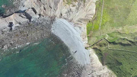 Top Down view of Cliffs and Farms over North Devon and Cornwall Coastpath Border Stock Footage 342452454