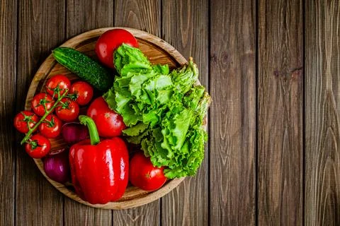 Top down view of close-up still life of fresh vegetables and herbs on wooden Stock Photos