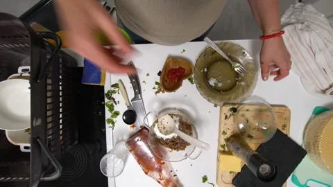 A top-down view of a cluttered kitchen countertop featuring a variety of cooking Stock Footage 336446131