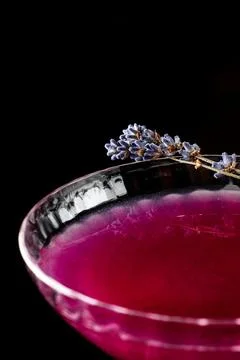 Top-down view of a cocktail featuring a delicate edible flower as decoration. Stock Photos