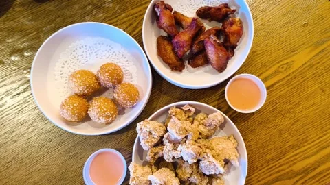 Top down view of coconut lava balls, chicken wings, and crispy fried popcorn chi Video stock 318128327