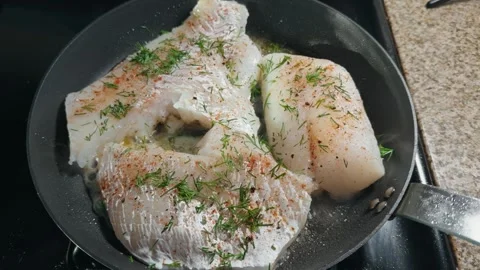 Top down view of cod fillets searing with fresh dill Stock Footage 330203588