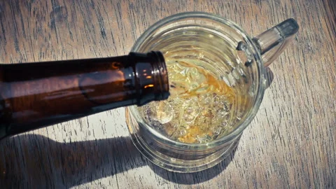 Top Down View of Cold Beer Pouring into Glass Mug with Frothy Foam Stock Footage 342970041