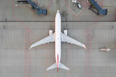 Top down view on comercial airplane docking in terminal in the parking lot Stock Photos