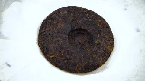 Top Down View of Compressed Pu-erh Tea Cake on White Paper Stock Footage 342224122