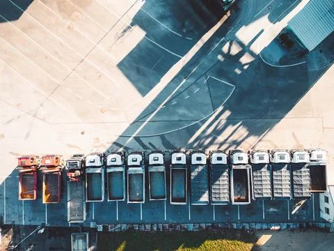 Top down view of construction trucks parked in a line at the road repair base Stock Photos