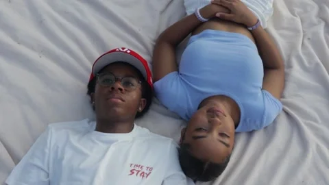 Top down view couple laying down on blanket in the park Stock Footage 285563929