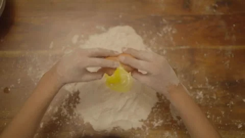 Top-down view of cracked egg above flour well Vidéo 336374779