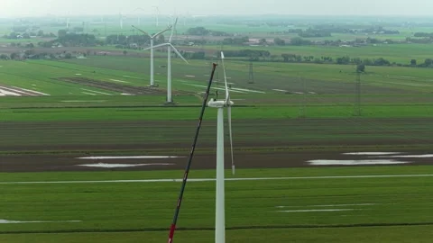 Top-down view of crane-assisted wind turbine repair with worker Stock Footage 320246258