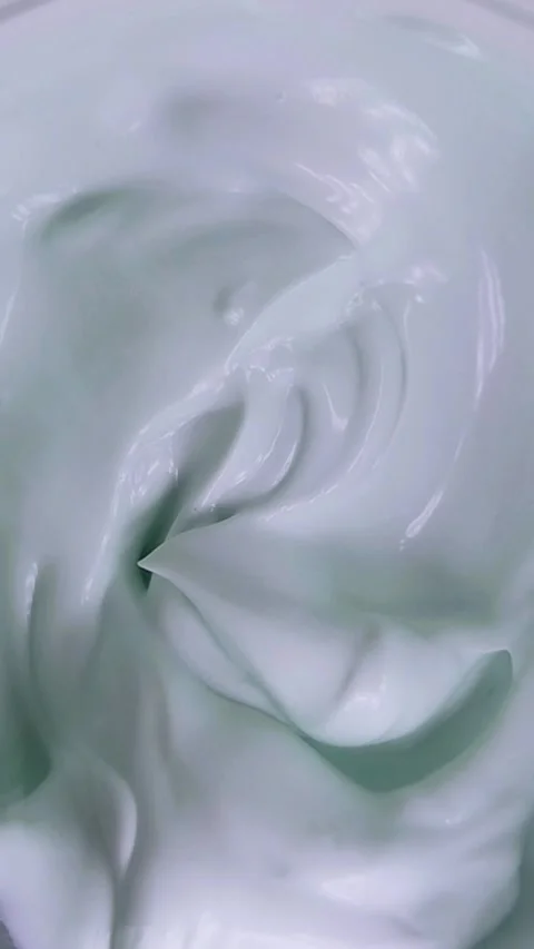 Top down view of cream being stirred slowly using a tool. Vertical video ca.. Stock Footage 339288819