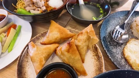 Top Down View of Crispy Fried Samosas and Asian Dishes on Table Stock Footage 345699988