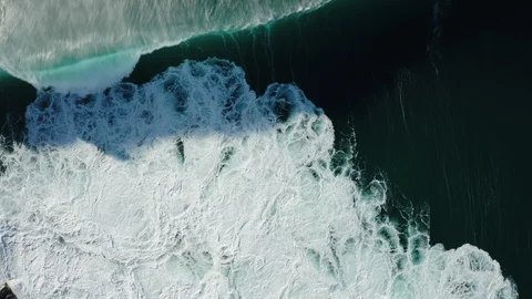 Top down view of crushing waves; blue water, thick seafoam, natural abstract pat Stock Footage 104945304