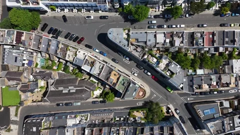 Top down view of a curving street of terraced roofs, chimney stacks and small Stock Footage 343472373