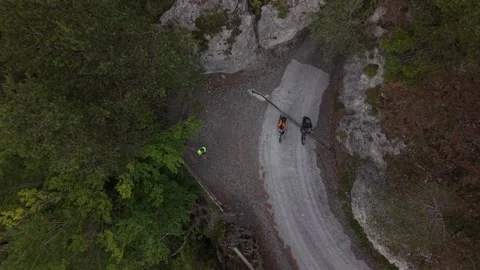 Top Down View of Cyclists Climbing Mountain Road After Tunnel Exit Stock Footage 336366776