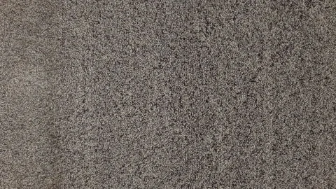 A top-down view of a dense, mottled carpet texture providing a neutral Stock Footage 340849067