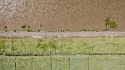 Top Down View of Dike Road and Brown Tidal Water Stock Photos