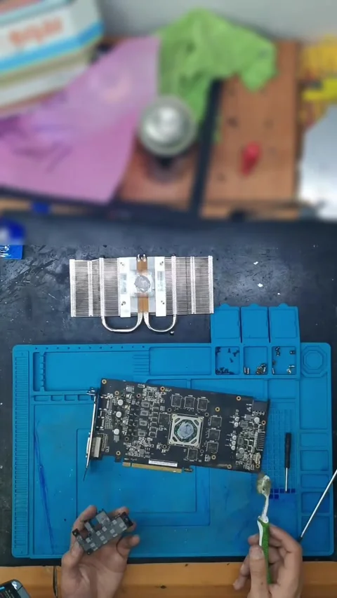 Top-down view of a disassembled high-end graphics card (GPU) on a blue magnetic Stock-Footage 333525358
