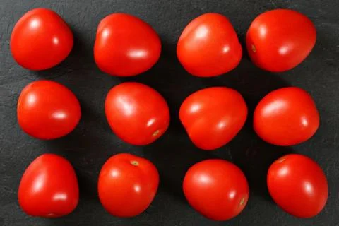 Top down view, dozen of mini tomatoes arranged on black stone desk Stock Photos