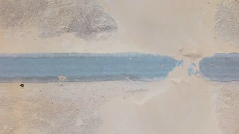 Top-Down View of Drone Moving with People Walking Along Beach Road, Sand Visible Stock Footage 306330574